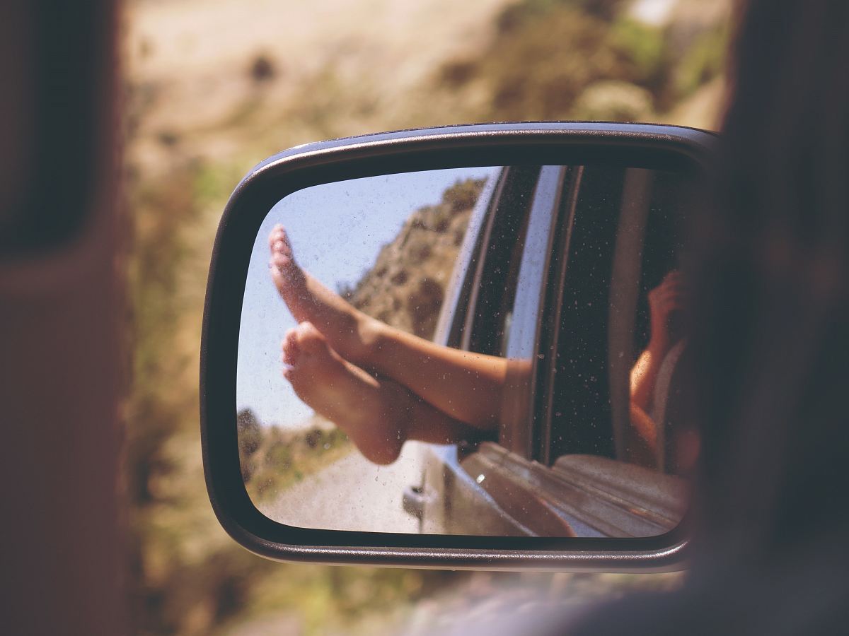 person's leg resting on vehicle window
